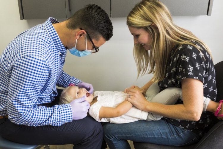 Pediatric Dentist looking at child